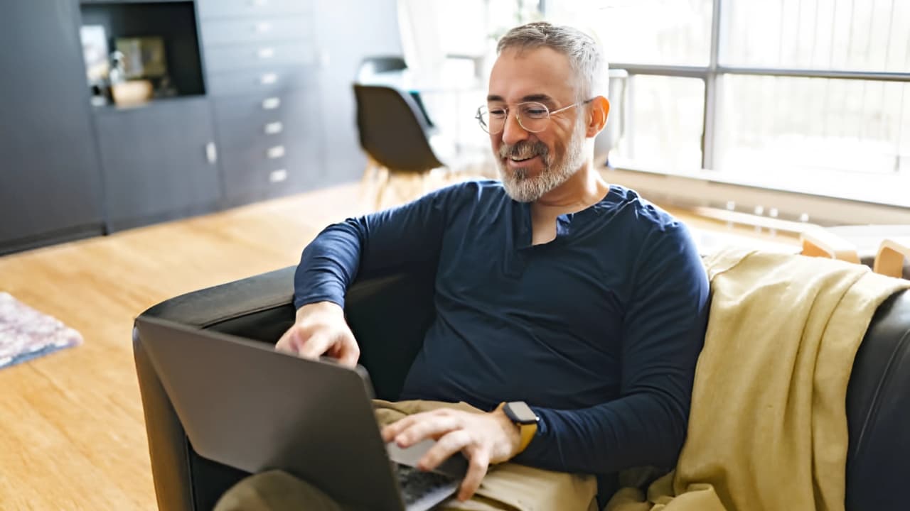 Parent with child on the grass using a laptop